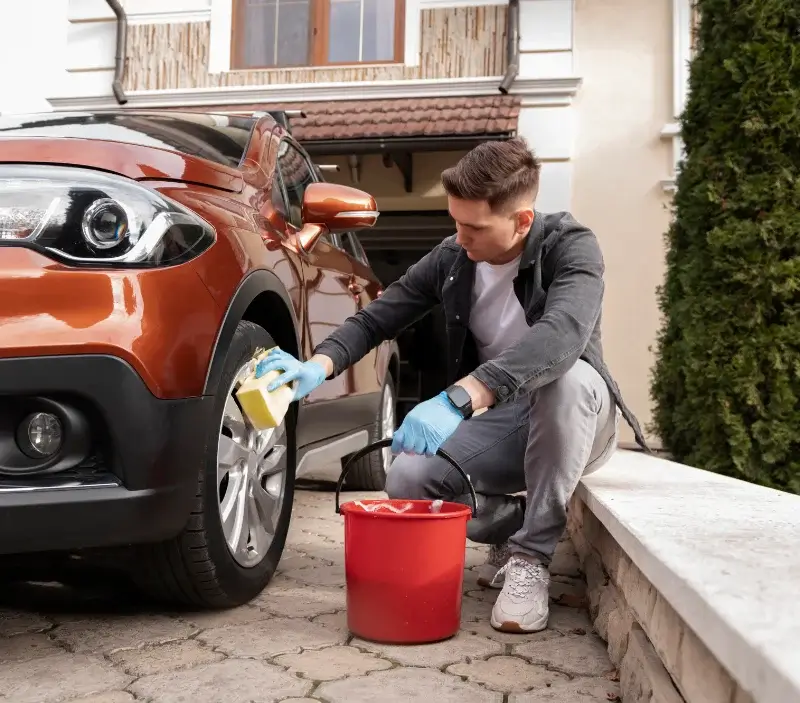 Lavage auto à domicile Villeneuve-les-Genêts : professionnel intervenant sur un véhicule